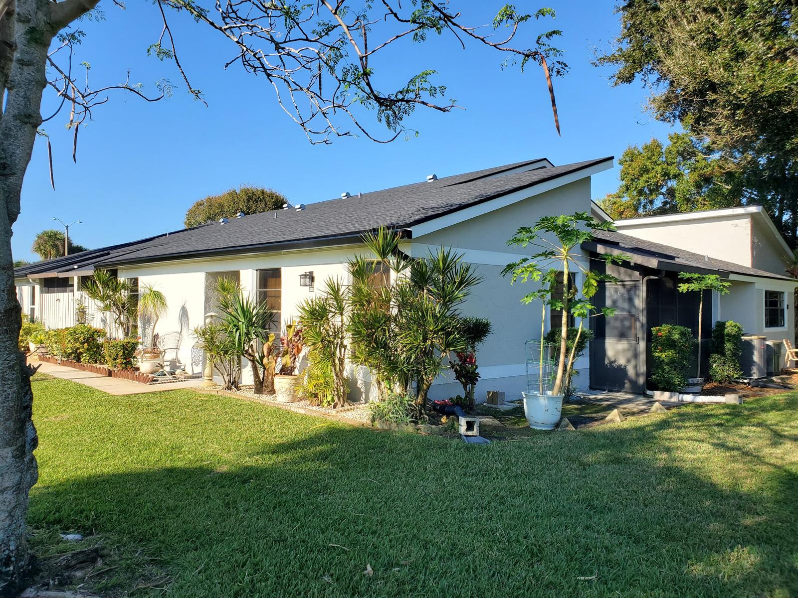 A single-story house with a dark shingled roof, light-colored stucco walls, and lush landscaping — 4327 Willow Brook Circle, West Palm Beach FL 33417, WEST PALM BEACH, FL