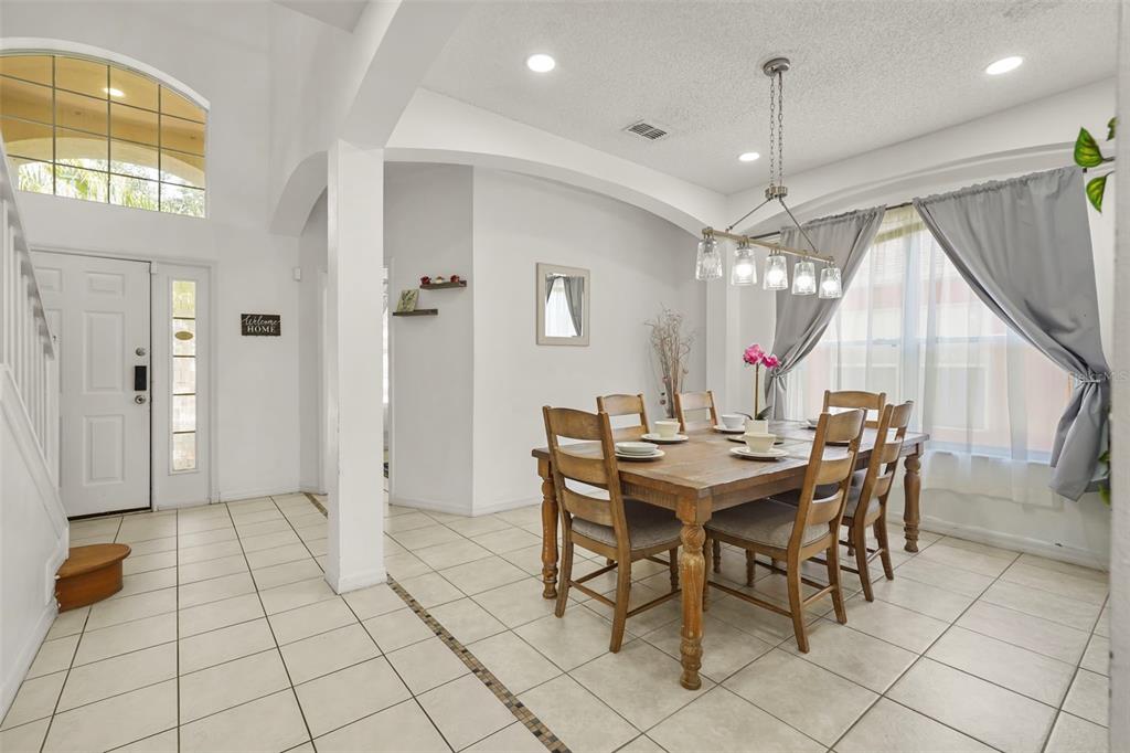 A dining room with a wooden table, chairs, tile flooring, and a chandelier — 1265 SEASONS BOULEVARD, KISSIMMEE, FL