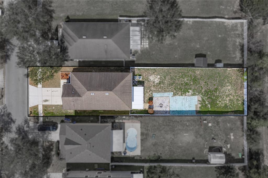 This aerial view shows a residential property with a house, driveway, and backyard — 13416 KENT BRADLEY STREET, DADE CITY, FL