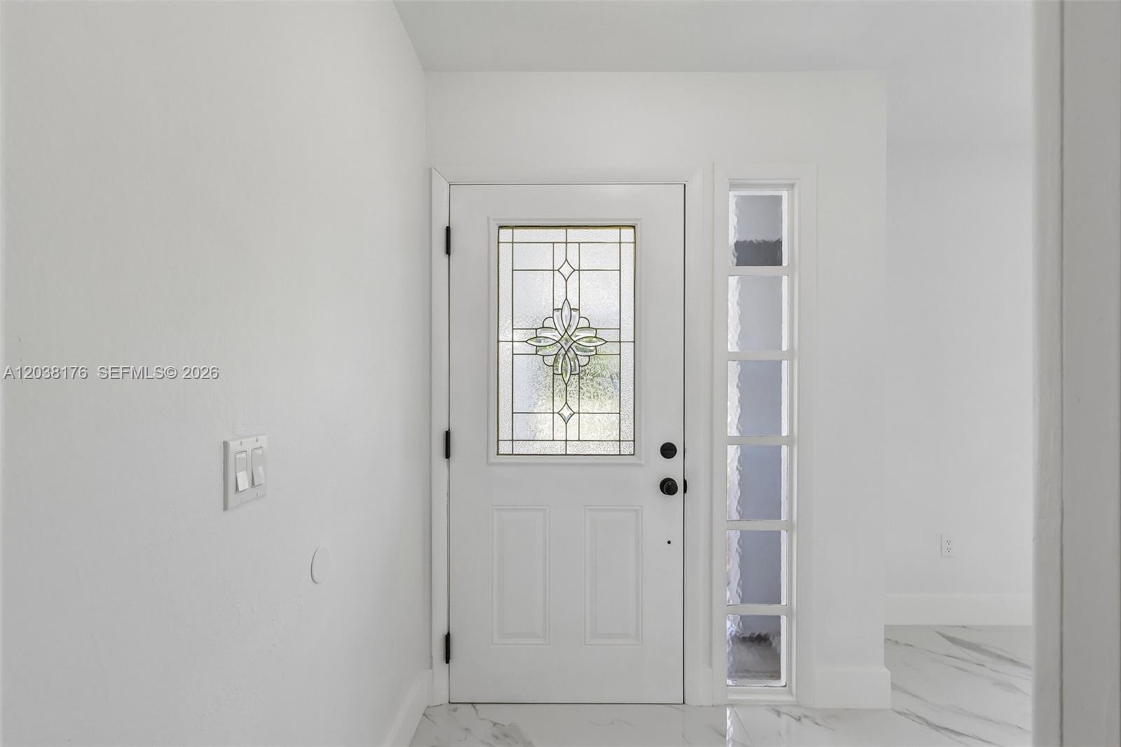 A white front door with a decorative glass insert stands beside a vertical sidelight window — 1248 Riviera, Palm Bay FL 32905, PALM BAY, FL
