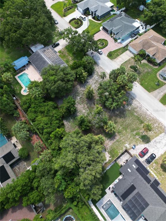 An aerial view shows a vacant residential lot surrounded by houses, trees, and swimming pools — 51ST AVENUE S, ST PETERSBURG, FL