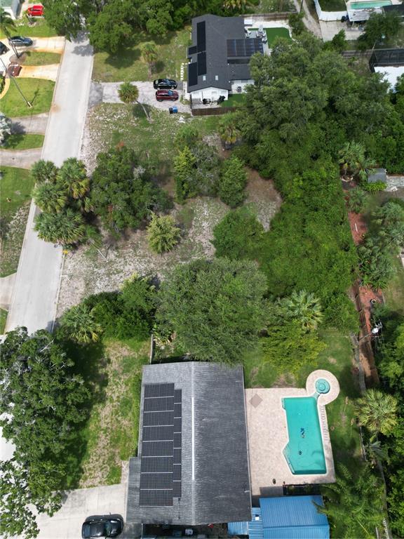 An aerial view shows a house with solar panels, a swimming pool, and surrounding trees — 51ST AVENUE S, ST PETERSBURG, FL