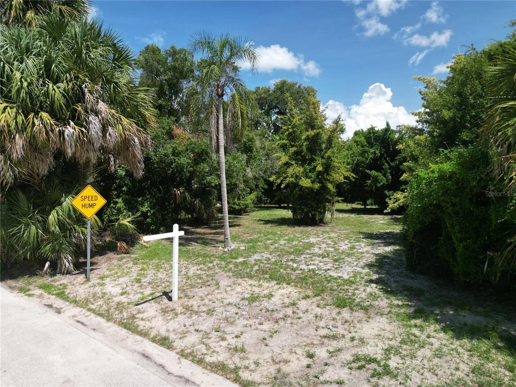 A vacant, wooded lot features a speed hump sign and a white real estate post — 51ST AVENUE S, ST PETERSBURG, FL