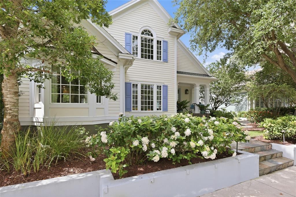 A two-story house with light siding, blue shutters, and a white concrete planter in front — 1798 LINCOLN PARK CIRCLE, SARASOTA, FL