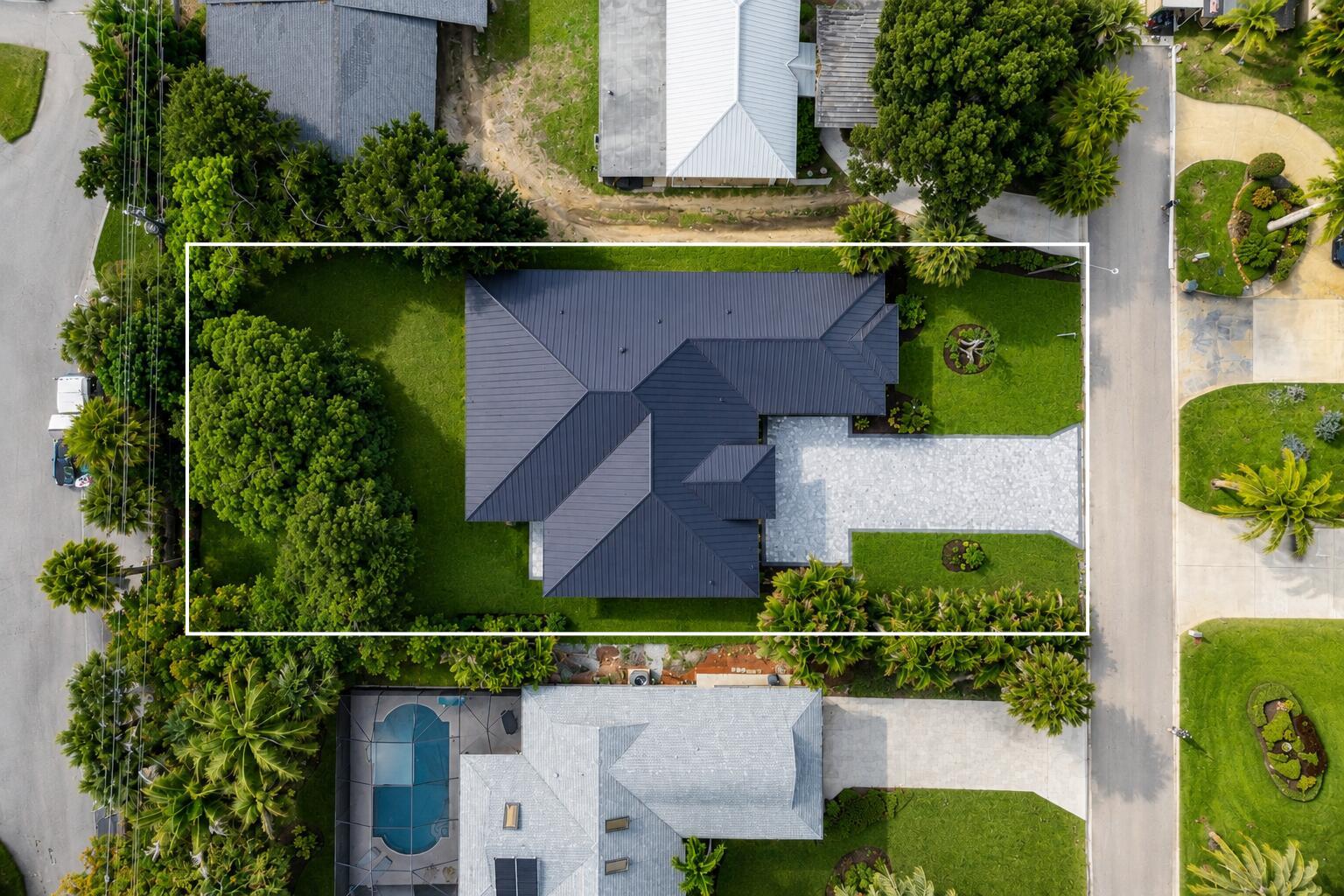 An aerial view shows a house with a dark metal roof and a paved driveway — 513 SW South Carolina Drive, Stuart FL 34994, STUART, FL
