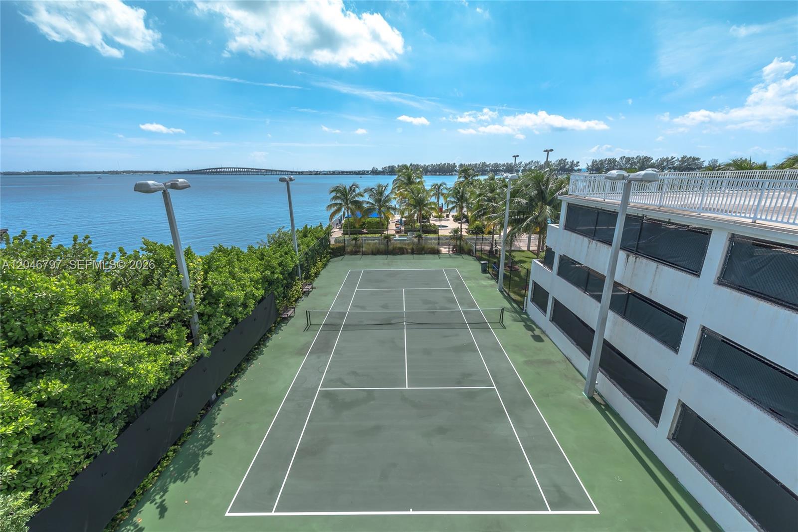 A living and dining area features dark wood flooring, a grey sectional sofa, and a balcony — 2101 Brickell Ave # 1501, Miami FL 33129, MIAMI, FL