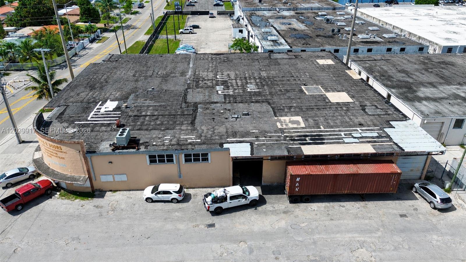 An aerial view shows a commercial warehouse building with a flat roof and a shipping container — 455 E 10th Ave, Hialeah FL 33010, HIALEAH, FL