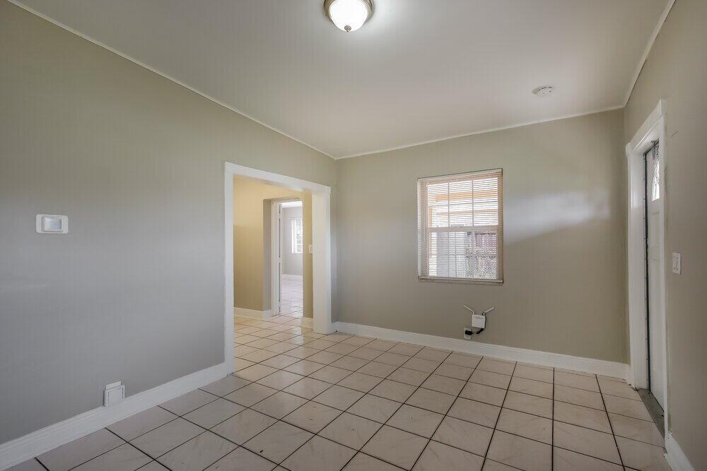 An empty room with light-colored walls, white trim, and light-colored floor tiles — MIAMI, FL