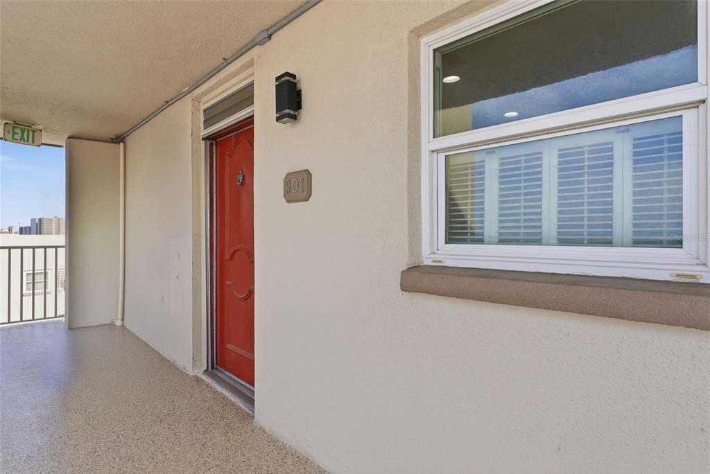A red front door with the number 901 is located on an outdoor apartment balcony — 5980 SHORE BOULEVARD S UNIT 901, GULFPORT, FL
