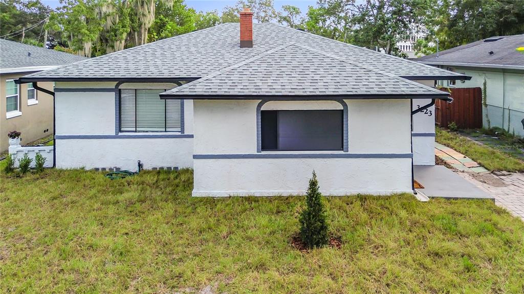 A single-story house with a white stucco exterior, gray trim, and a gray shingled roof — 3223 N ORANGE AVE, ORLANDO, FL