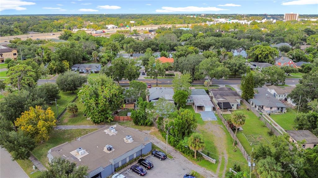 An aerial view shows a commercial building with a parking lot next to residential houses — 3223 N ORANGE AVE, ORLANDO, FL