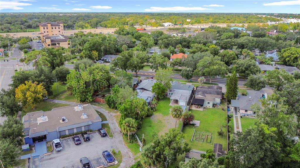 An aerial view shows a commercial building with a parking lot next to residential houses — 3223 N ORANGE AVE, ORLANDO, FL