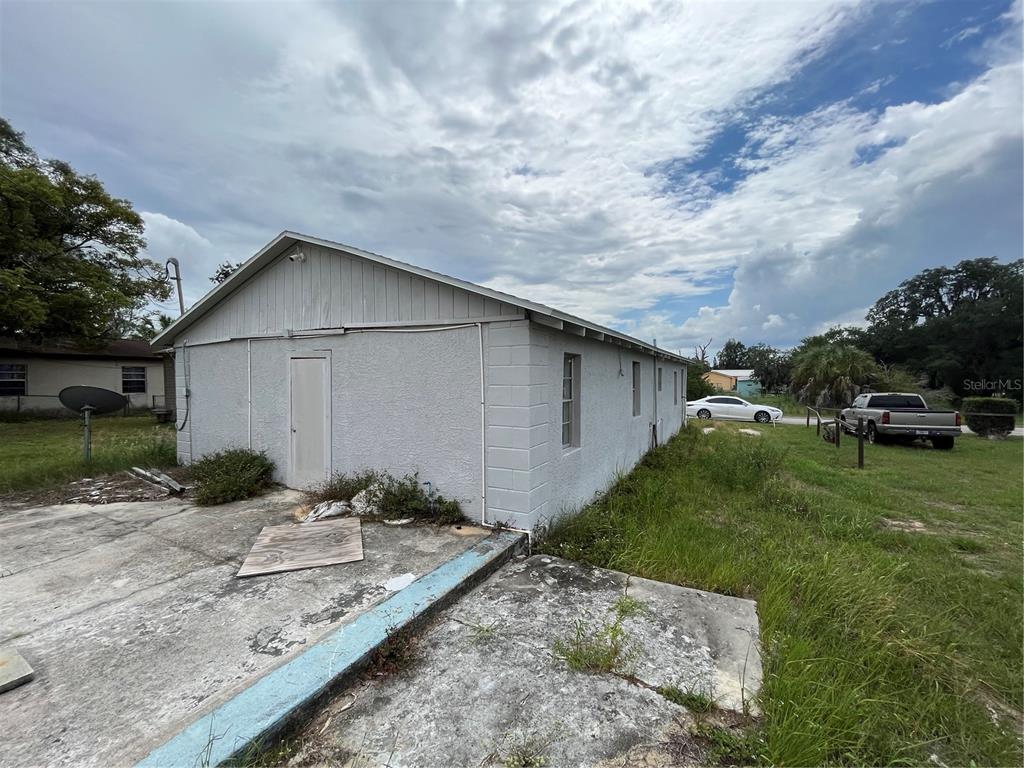 A gray concrete block building with a side door and a concrete patio area — 852 SHIRLEY STREET, SEBRING, FL
