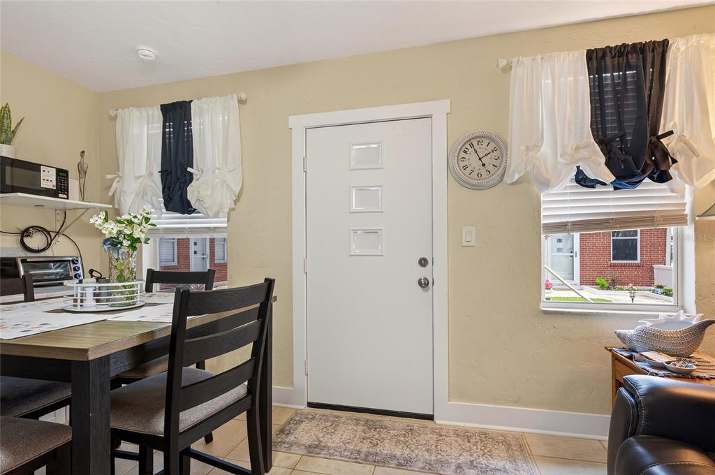 A dining area features a wooden table, a white door with three windows, and two windows — 908 VILLAS DRIVE UNIT 29, VENICE, FL