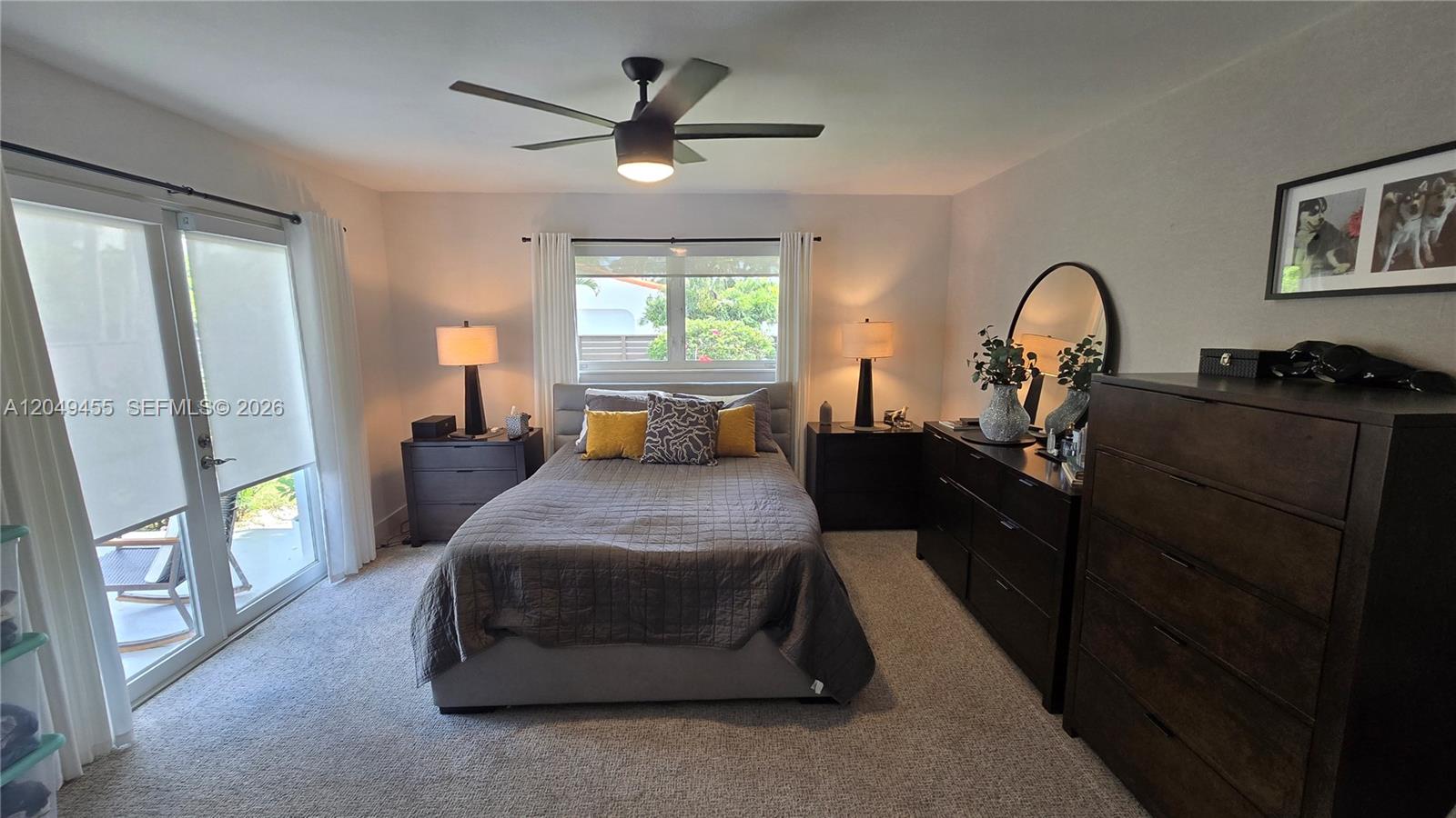 A bedroom features a bed, dark wood furniture, a ceiling fan, and sliding glass doors — 800 Polk St, Hollywood FL 33019, HOLLYWOOD, FL