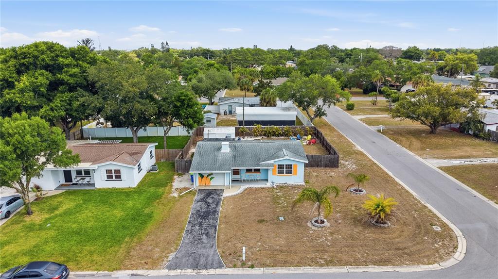 An aerial view shows a light blue house with a driveway and a large front yard — 10437 52ND AVENUE N, ST PETERSBURG, FL