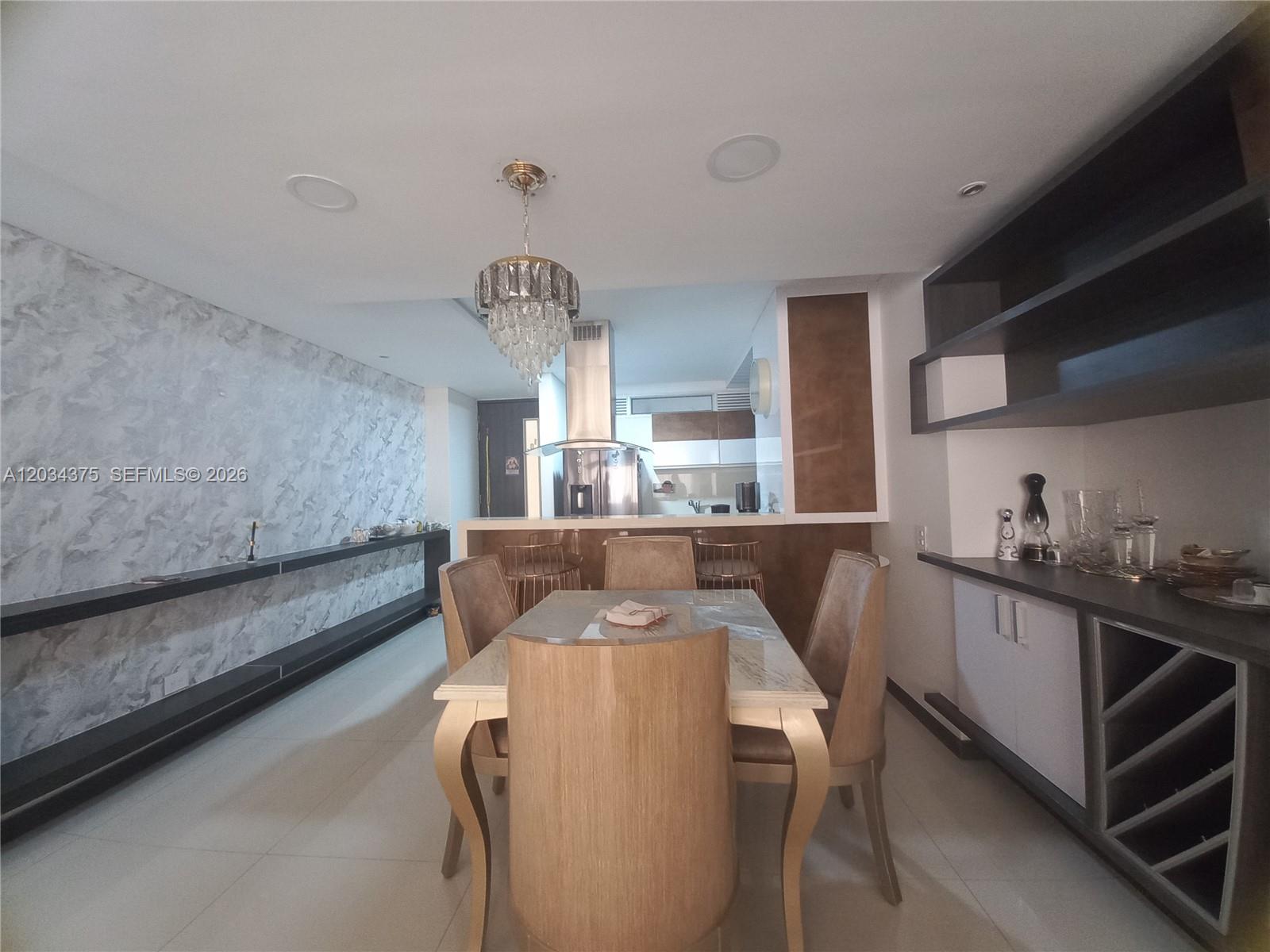 A dining area features a table with four chairs, a crystal chandelier, and marble-patterned walls — Cra. 19 # 9 - 110 # 101, FL, FL