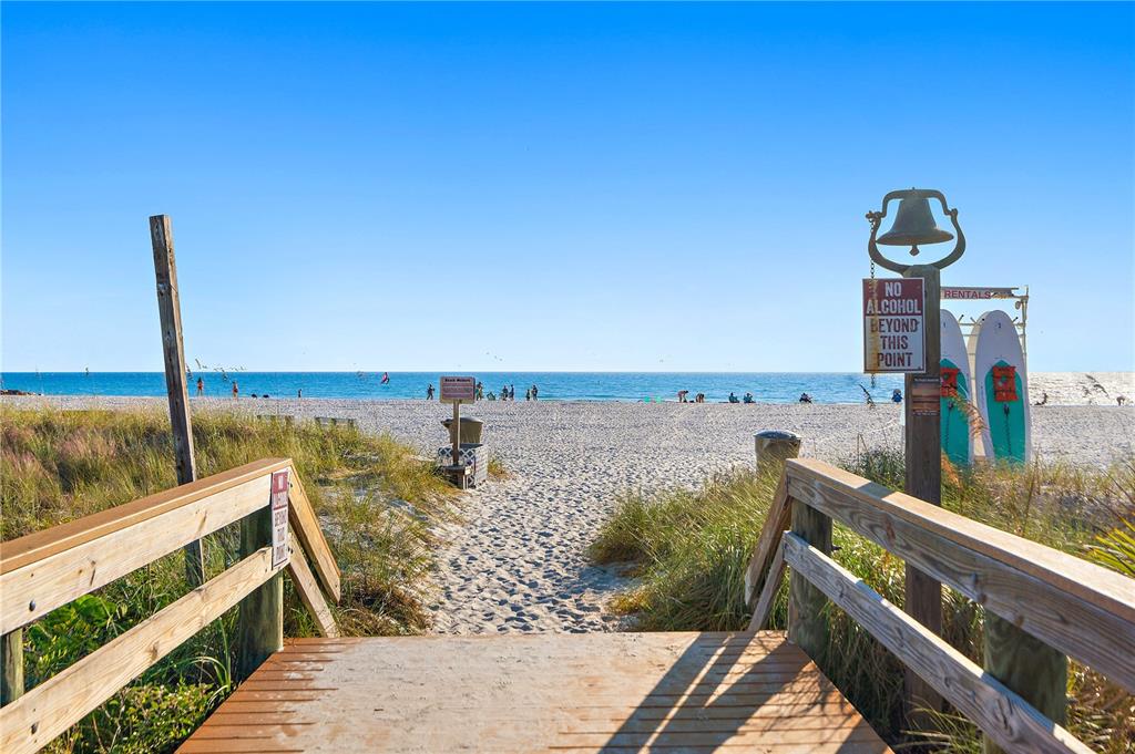 A wooden walkway leads to a sandy beach with a sign prohibiting alcohol — 680 71ST AVENUE UNIT 12, ST PETE BEACH, FL