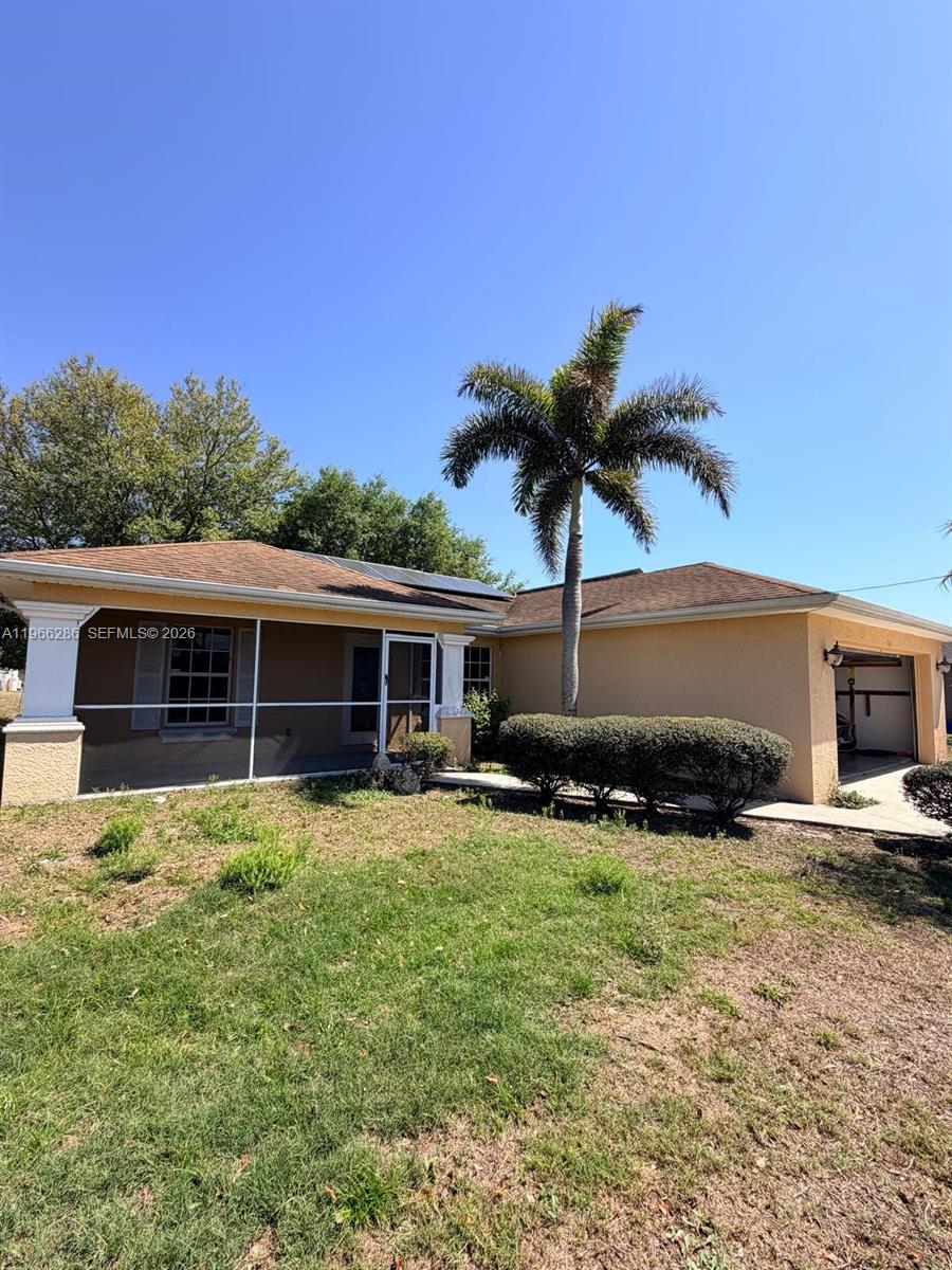 A single-story house with a screened-in porch, a palm tree, and an attached garage — 507 Peerless Cir, Lehigh Acres FL 33974, LEHIGH ACRES, FL
