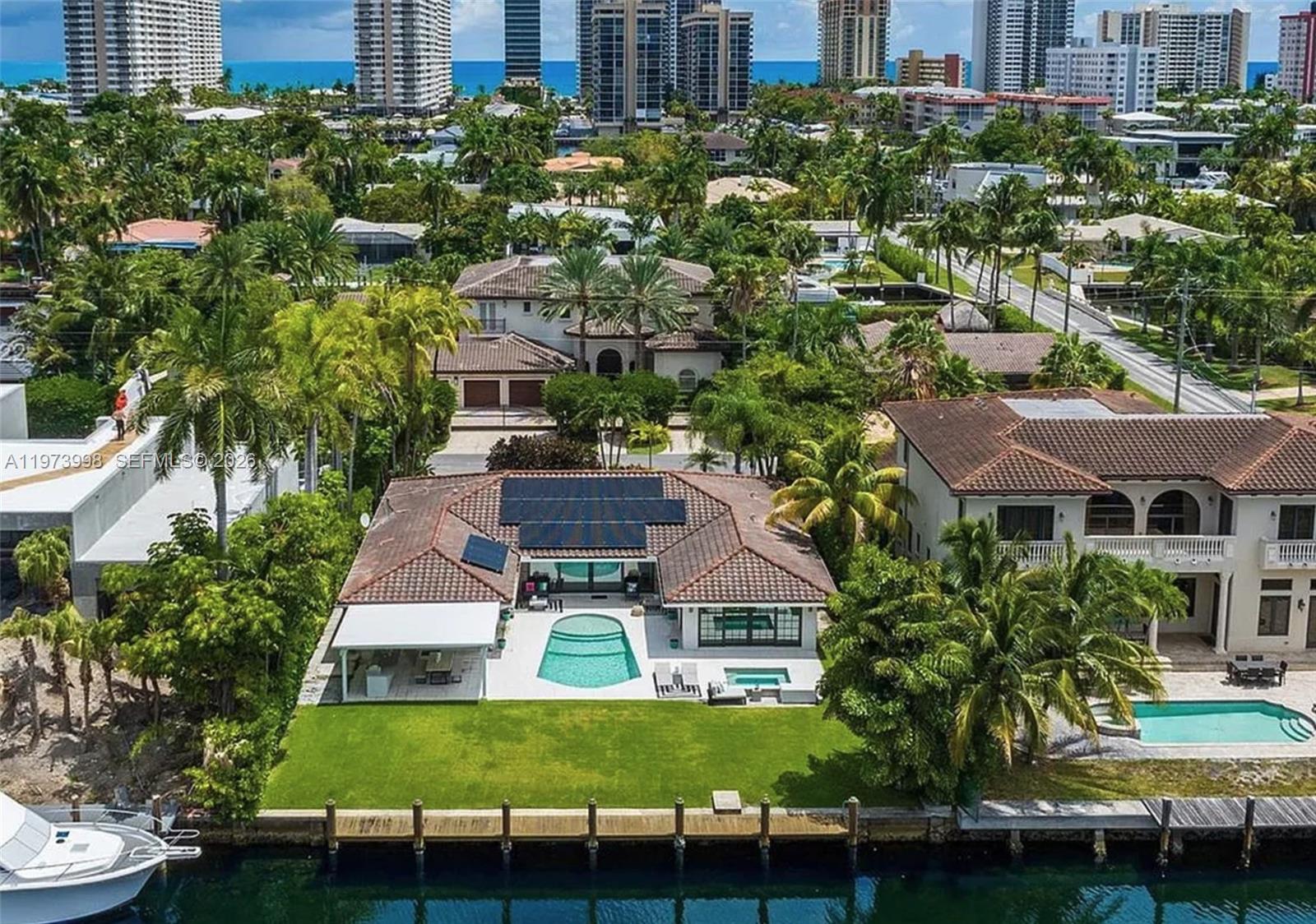 An aerial view of a waterfront house with a pool, solar panels, and a boat dock — 524 Oleander Dr, Hallandale Beach FL 33009, HALLANDALE BEACH, FL