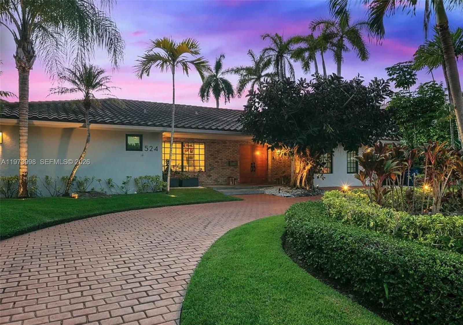 A single-story house with a brick facade, a curved brick driveway, and palm trees — 524 Oleander Dr, Hallandale Beach FL 33009, HALLANDALE BEACH, FL