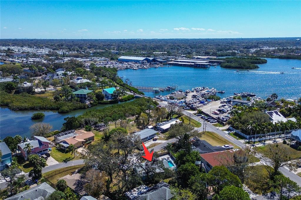 An aerial view shows a residential neighborhood with a pool and a nearby marina — 201 SOUTH STREET, PALM HARBOR, FL