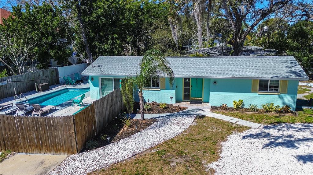 An aerial view of a light blue single-story house with a pool and gravel driveway — 201 SOUTH STREET, PALM HARBOR, FL