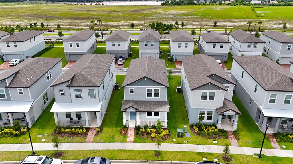 An aerial view shows a row of modern, two-story suburban houses with gray siding — 4630 HOMESTEAD TRAIL, ST CLOUD, FL