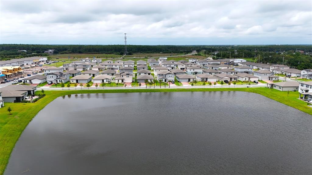 An aerial view shows a large retention pond in front of a suburban housing development — 4630 HOMESTEAD TRAIL, ST CLOUD, FL