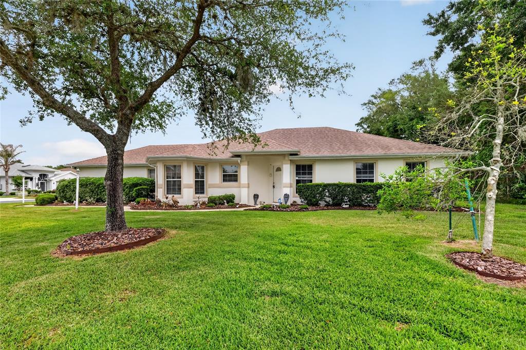 A single-story house with a light-colored exterior, a hip roof, and a large front lawn — 27545 DISCOVER COURT, LEESBURG, FL