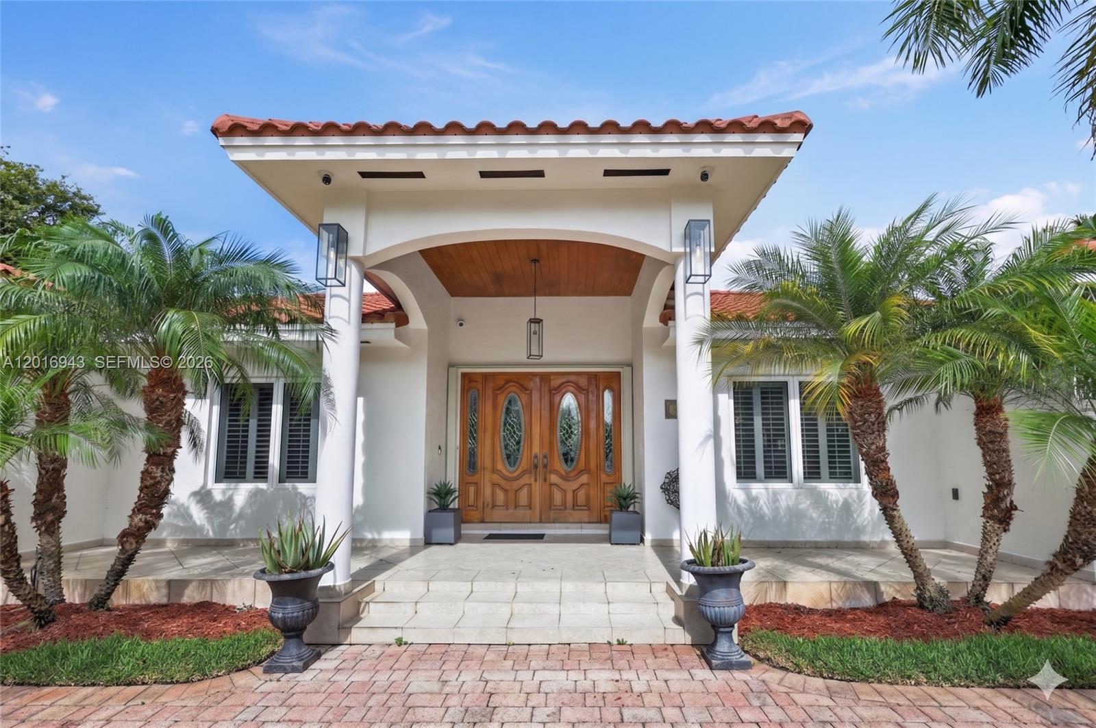 The exterior of a house features a covered entryway with double doors and two palm trees — 18461 SW 83rd Ave, Cutler Bay FL 33157, CUTLER BAY, FL