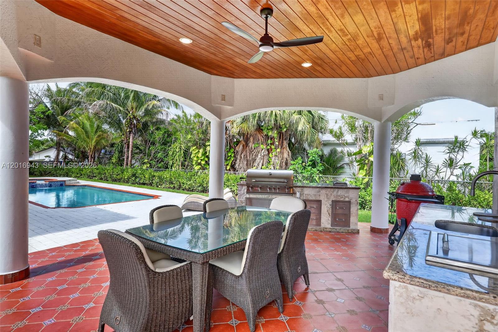 A covered outdoor patio features a dining set, a built-in grill, and a swimming pool — 18461 SW 83rd Ave, Cutler Bay FL 33157, CUTLER BAY, FL