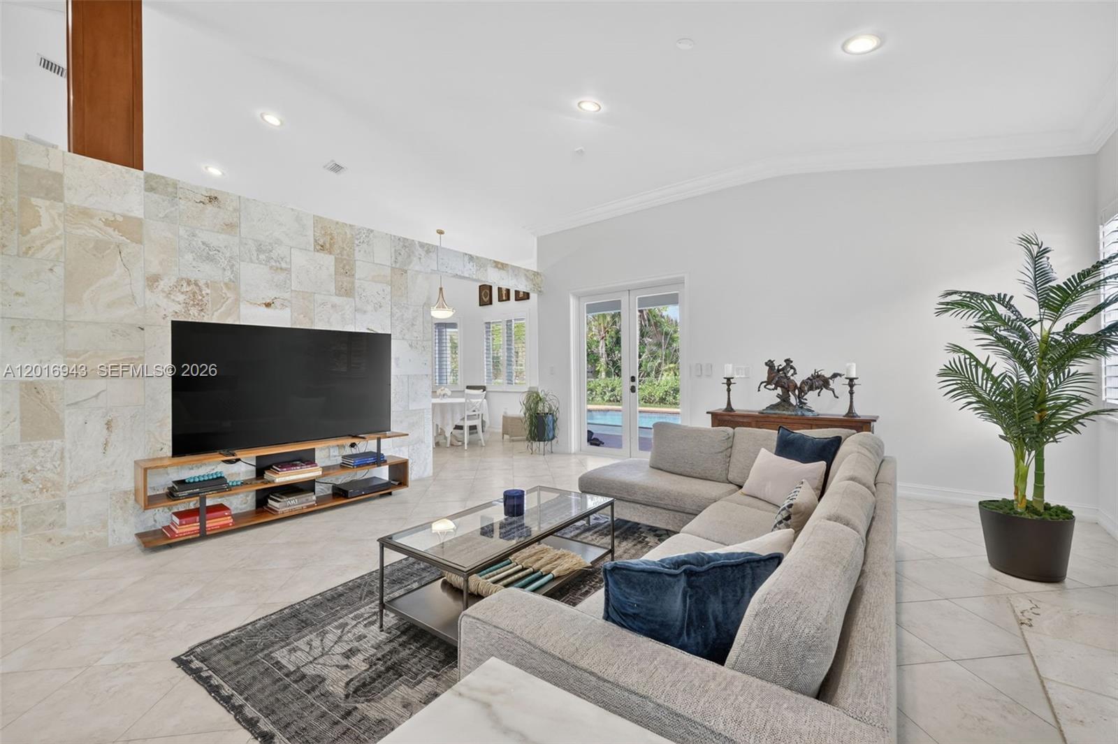 A living room features a stone accent wall, a large sectional sofa, and glass doors — 18461 SW 83rd Ave, Cutler Bay FL 33157, CUTLER BAY, FL