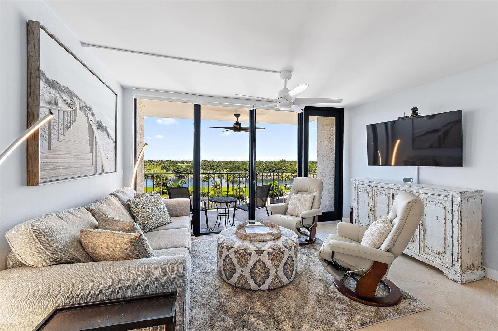 A living room features a sofa, two recliners, a patterned ottoman, and a balcony view — 336 Golfview Road # 619, North Palm Beach FL 33408, NORTH PALM BEACH, FL