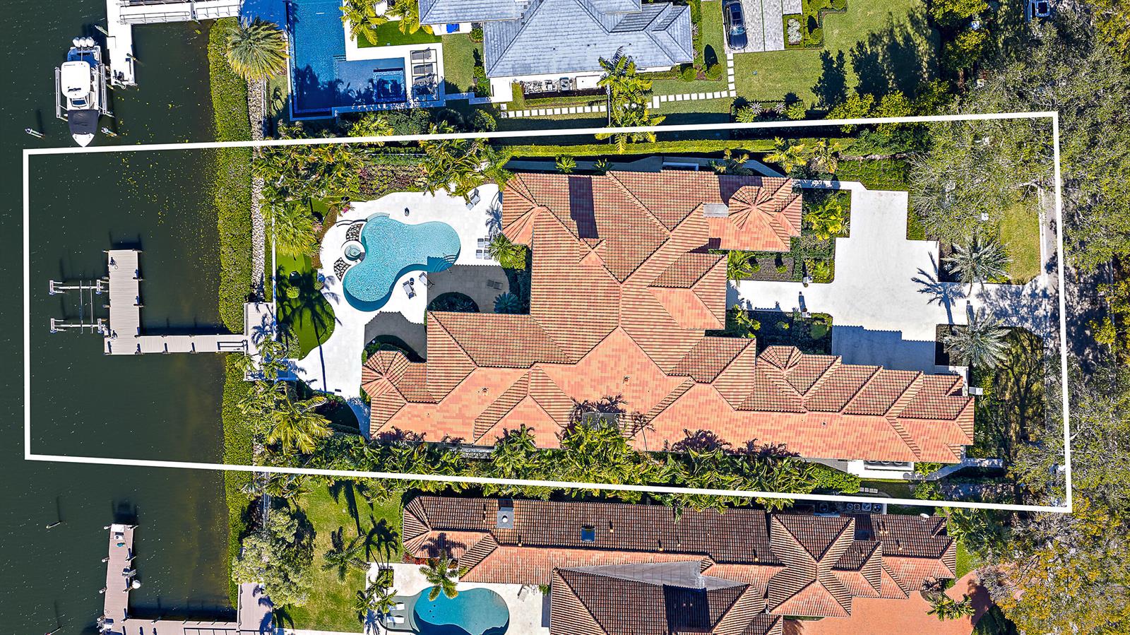 A luxury house exterior with a three-car garage, paved driveway, and lush tropical landscaping — 466 Mariner Drive, Jupiter FL 33477, JUPITER, FL