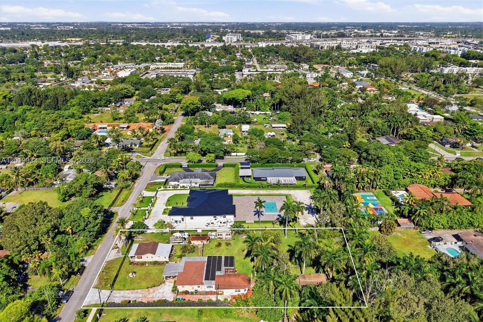 An aerial view shows a residential property with two houses, palm trees, and a yard — 55-57 NE 156th St, Miami FL 33162, MIAMI, FL