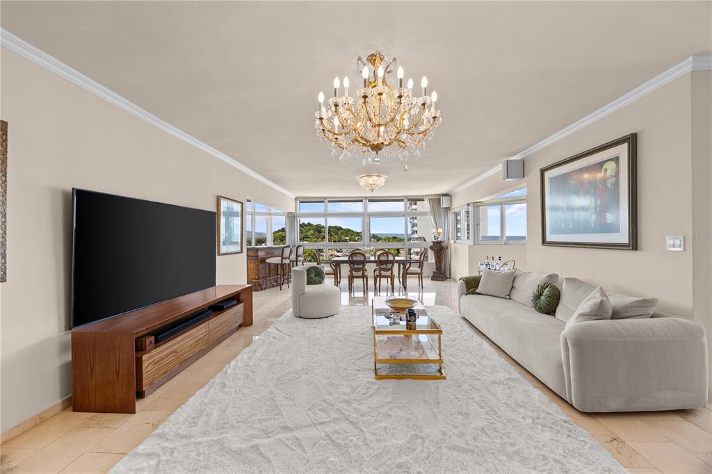 A living room features a large chandelier, a white rug, a sofa, and a television — 14 CARR 833 UNIT 1404, GUAYNABO, PR
