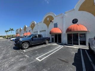 A blue pickup truck is parked in front of a commercial building with orange awnings — 13860 SW 143rd Ct # 2, Miami FL 33186, MIAMI, FL