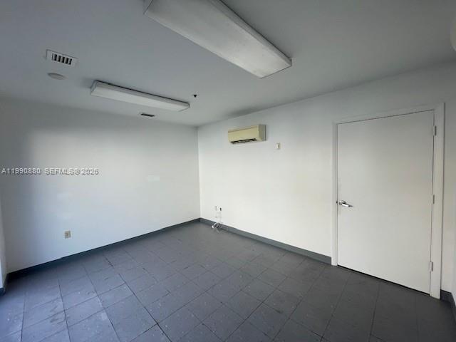 An empty room features white walls, a gray tiled floor, and a white door — 13860 SW 143rd Ct # 2, Miami FL 33186, MIAMI, FL