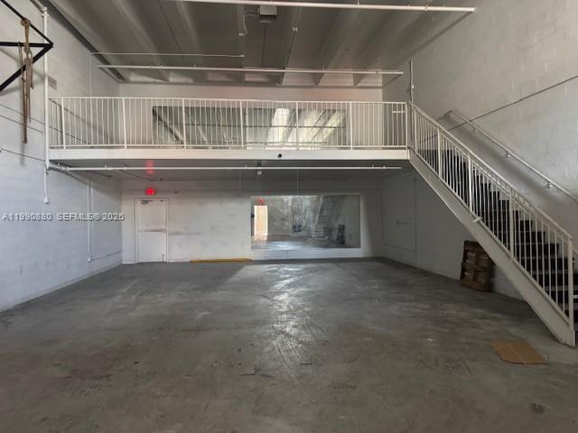 An industrial warehouse space features a concrete floor, a mezzanine level, and a staircase — 13860 SW 143rd Ct # 2, Miami FL 33186, MIAMI, FL