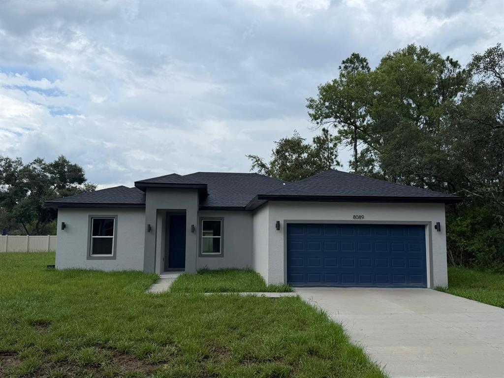 An open-concept kitchen and living area features white cabinets, a center island, and wood-look flooring — 7980 N PITCAIRN WAY, CITRUS SPRINGS, FL