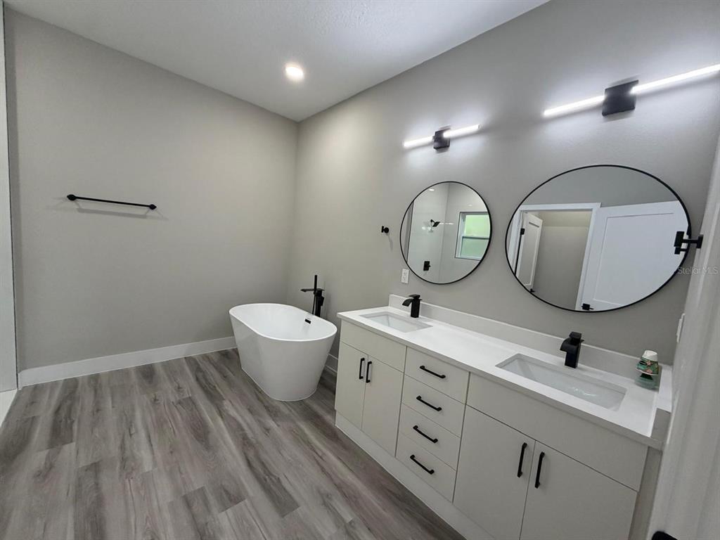 A modern kitchen features white cabinets, stainless steel appliances, and a quartz-topped island with sink — 7980 N PITCAIRN WAY, CITRUS SPRINGS, FL