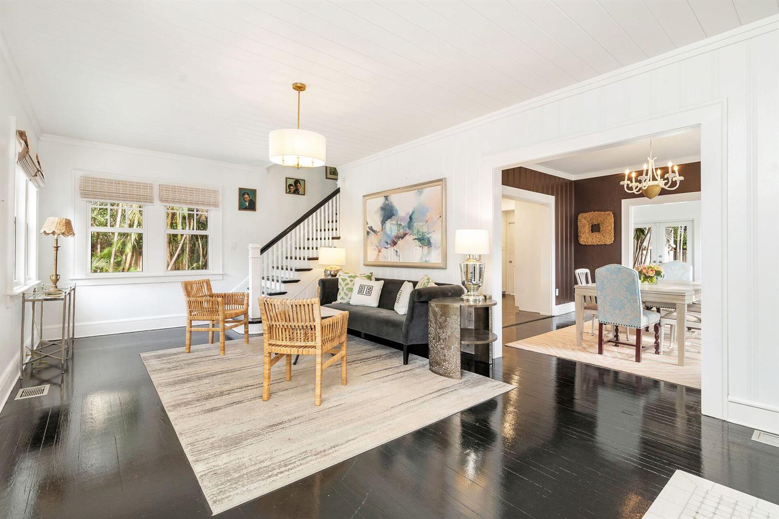 A living room with dark wood floors, a grey sofa, and a staircase — 3504 S Olive Avenue, West Palm Beach FL 33405, WEST PALM BEACH, FL