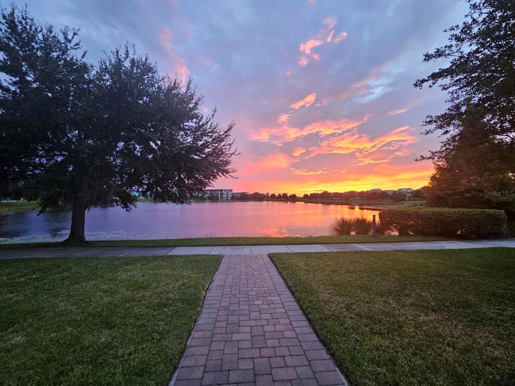 A paved walkway leads to a lake view at sunset with trees on both sides — 13416 BEEBE ALLEY, ORLANDO, FL
