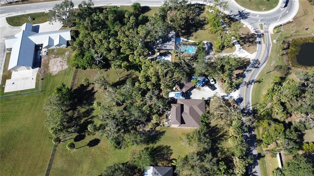 An aerial view shows a house with a pool, surrounded by trees and a road — 6500 RICHARDSON ROAD, SARASOTA, FL