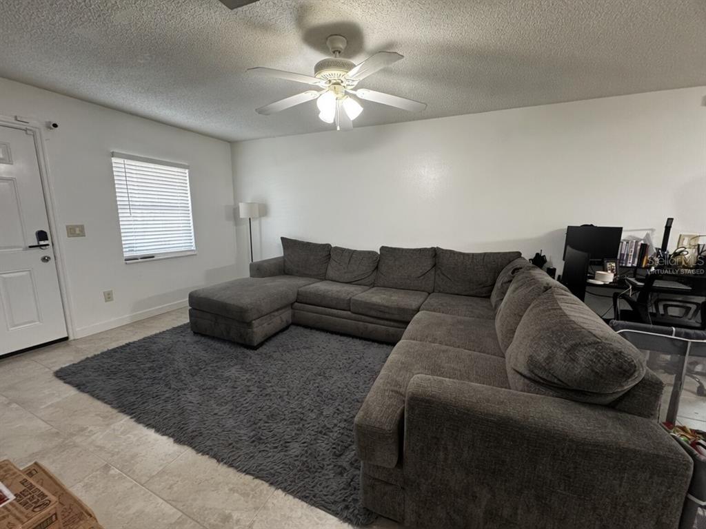A living room features a large gray sectional sofa, a matching area rug, and a ceiling fan — 31 DEACON JONES BOULEVARD UNIT A & B, ORLANDO, FL