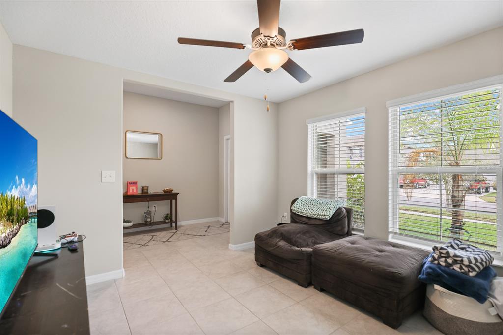 A living room features tile flooring, a ceiling fan, and a large window with blinds — 16640 CARLTON POND STREET, WIMAUMA, FL