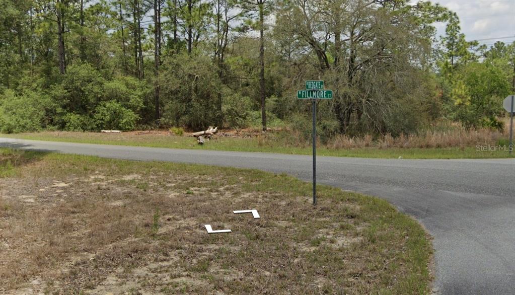 A street sign stands at the intersection of a paved road near a wooded area — 3091 W REDGATE DRIVE, DUNNELLON, FL