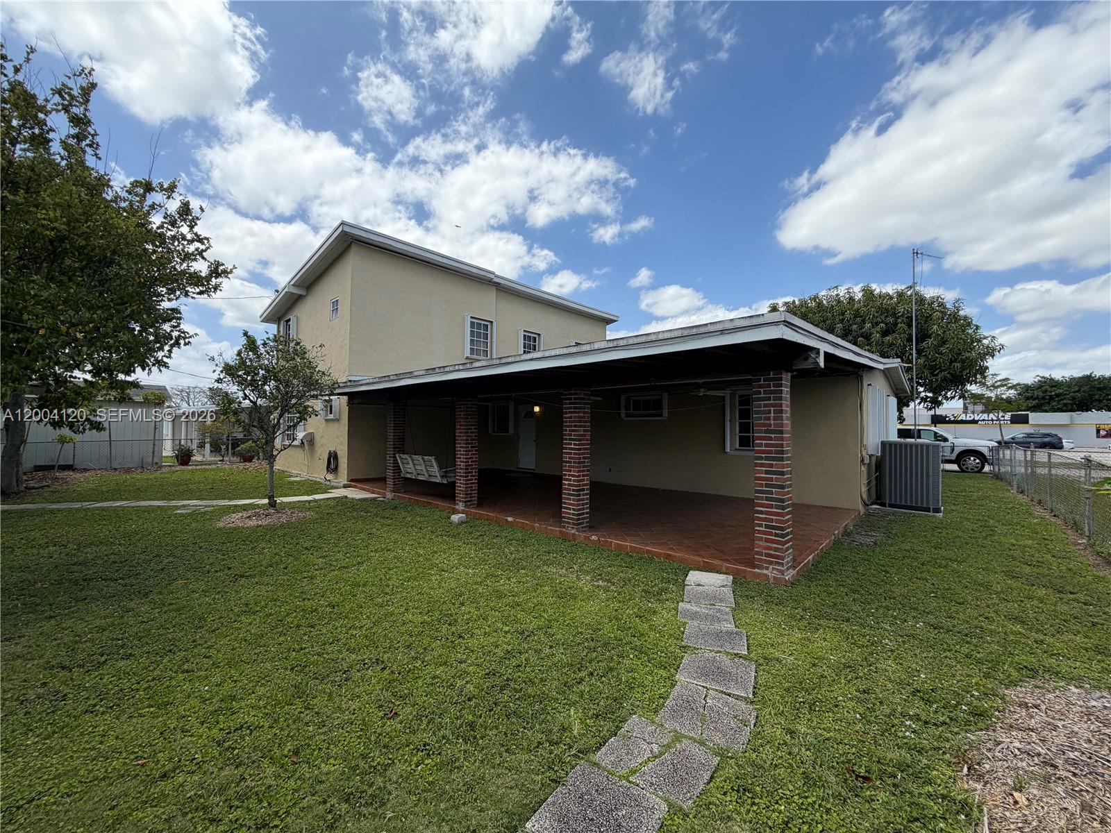 A two-story house features a large covered patio with brick columns and a stone walkway — 10910 SW 40th St, Miami FL 33165, MIAMI, FL