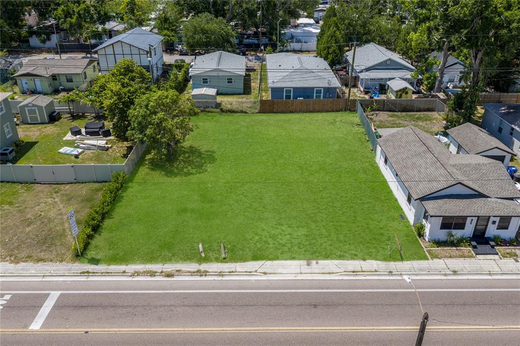 An aerial view shows a vacant, rectangular grass lot situated between two residential properties — 15TH AVENUE S, ST PETERSBURG, FL